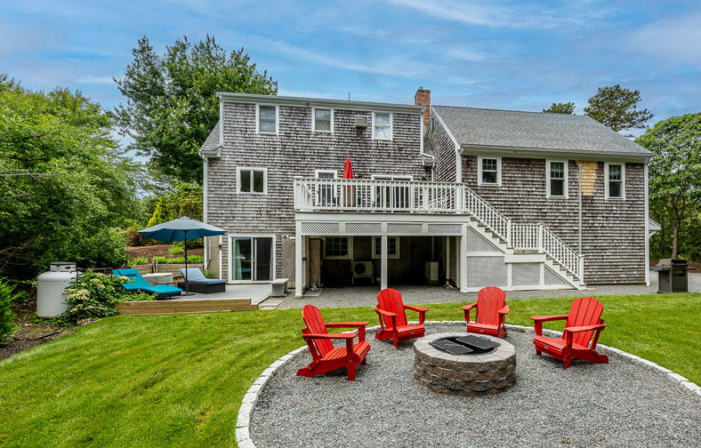 A view of the fire pit and backyard from the back of the vacation rental.